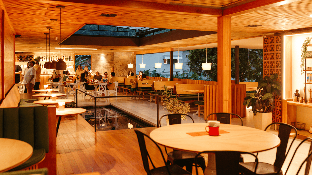 Restaurant dining area showcasing a clean, modern interior with wooden finishes, comfortable seating, and a welcoming atmosphere, highlighting a professional hygiene environment for restaurants.